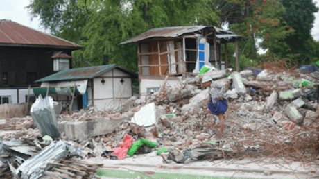 : A local resident steps across remnants of a home destroyed by the recent earthquake. Photo by Stephanie Xu, © 2025