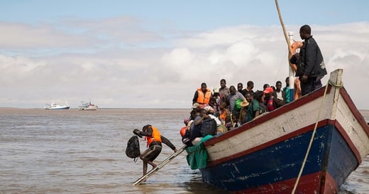 Climate refugees getting off a wooden boat.