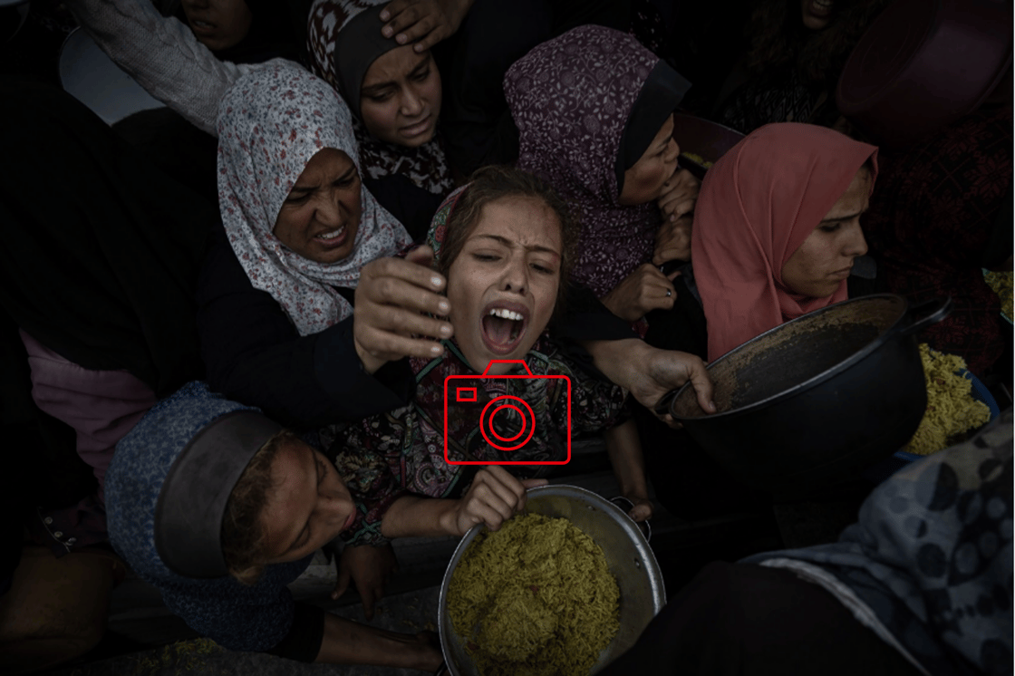 Palestinian women struggle to get food from a community kitchen amid a worsening crisis in Khan Younis, southern Gaza Strip.
