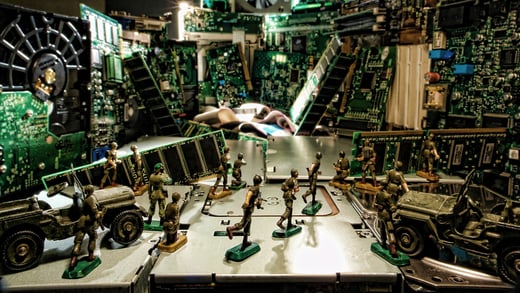 Toy soldiers standing in front of some computer mainboard.