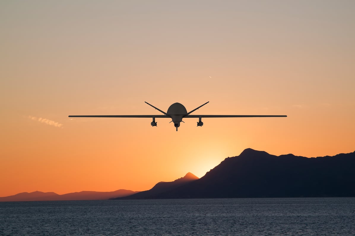 Silhouette of spy drone flying over the sea